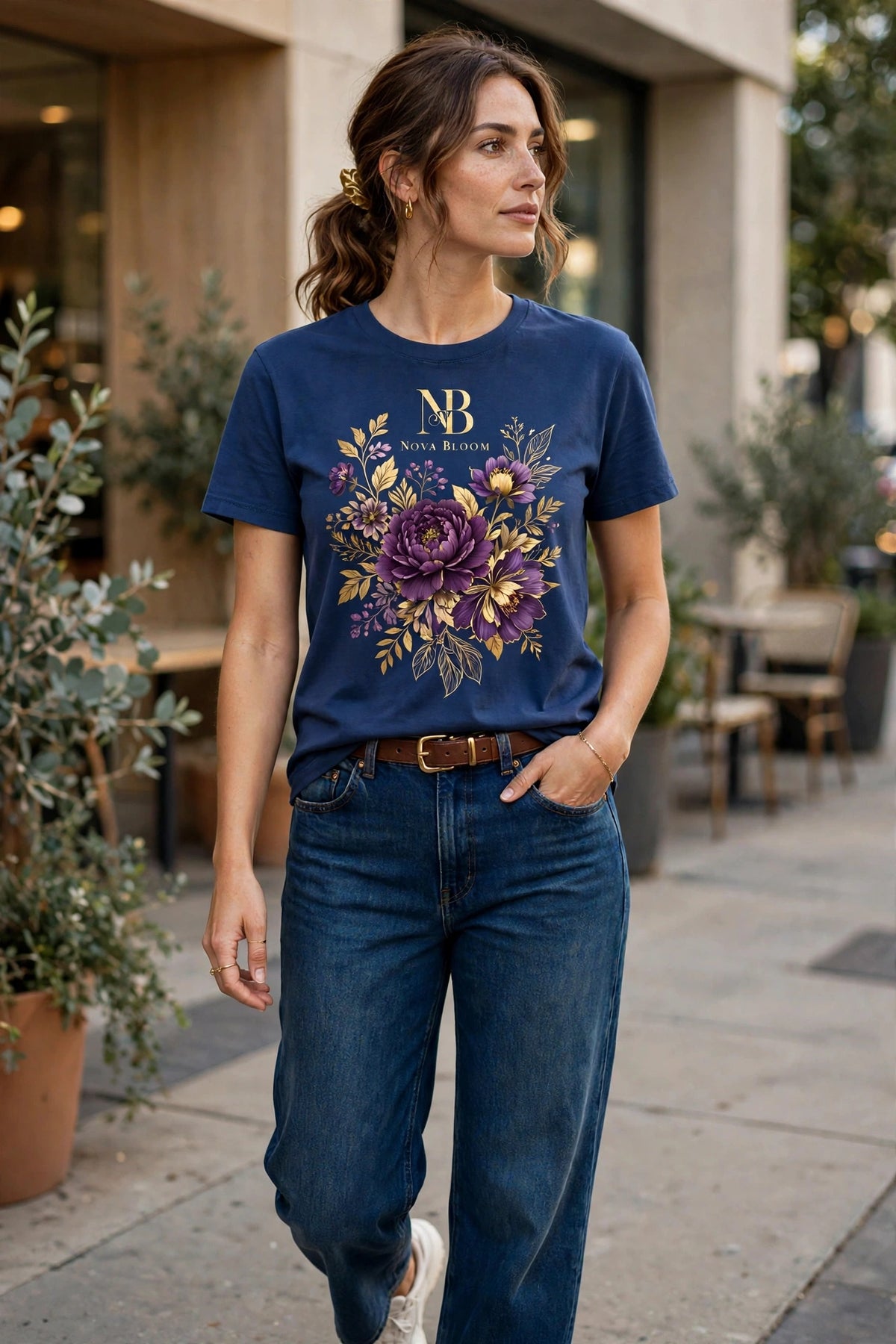Woman wearing Blue Nova Bloom Royale Floral T-Shirt with gold NB logo on top